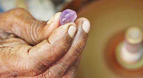 A person holding an uncut gem