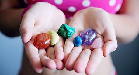 A person holding uncut gems in their hands
