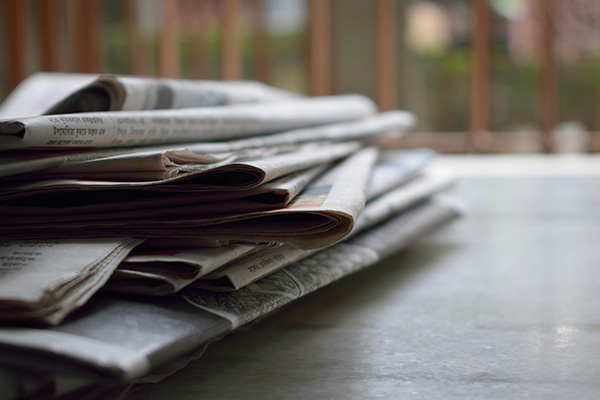 A stack of news papers on a table 